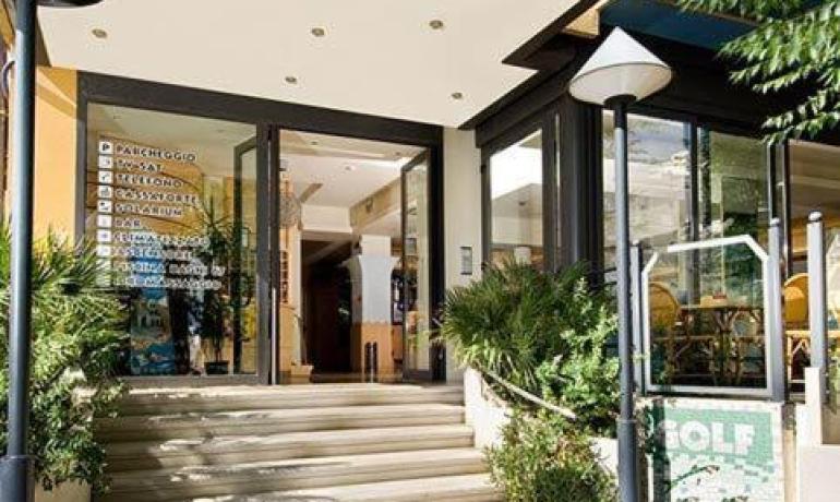 Ingresso di un hotel moderno con scale e insegne.
