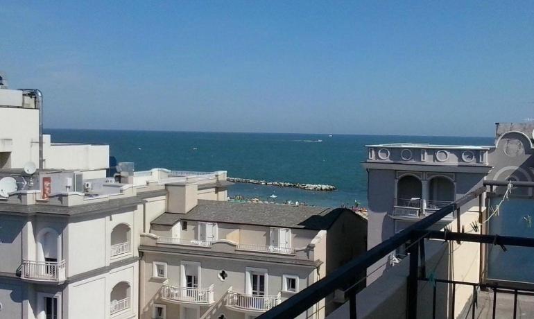 Meerblick von einem Balkon mit Gebäuden und Strand.